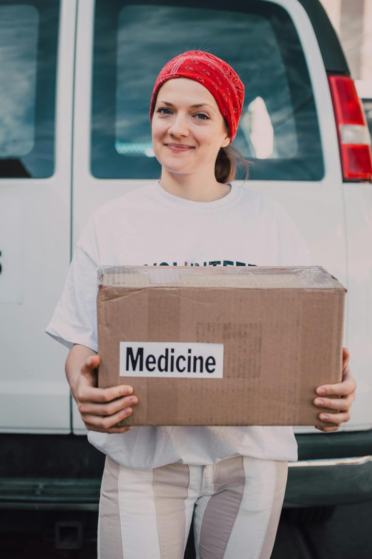 Man in White Crew Neck T-shirt Holding Brown Cardboard Box